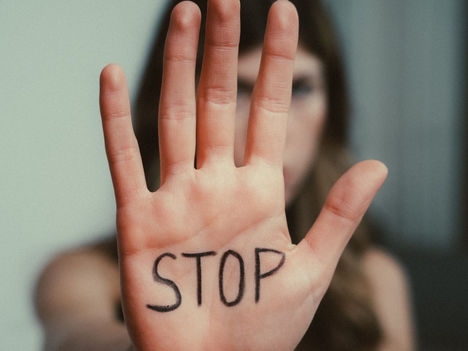 Eine ausgestreckte Handfläche, auf die das Wort Stop geschrieben ist