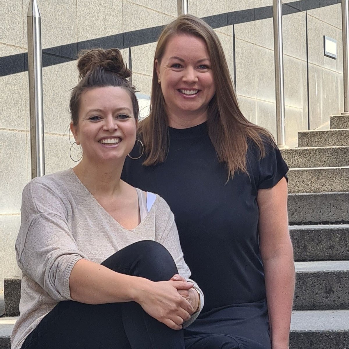 Michaela und Marion sitzen nebeneinander auf einer Treppe